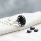 [KI] Silberring mit Onyx auf hellem Stoff