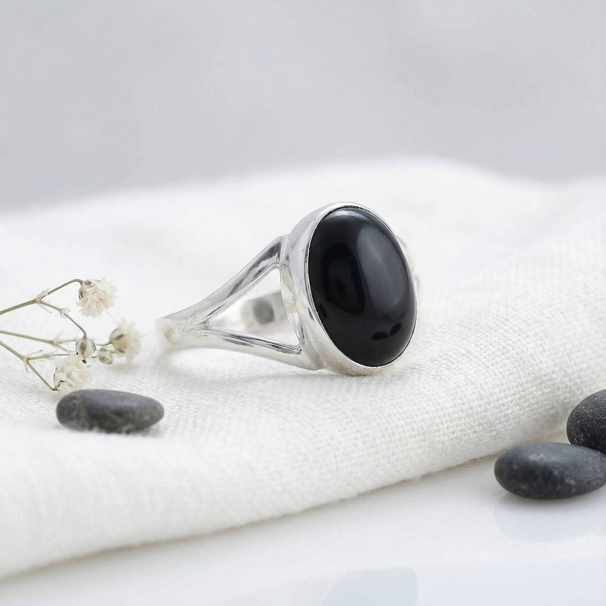 Silberring mit Onyx auf hellem Stoff
