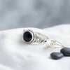 [KI] Silberring mit Onyx auf hellem Stoff