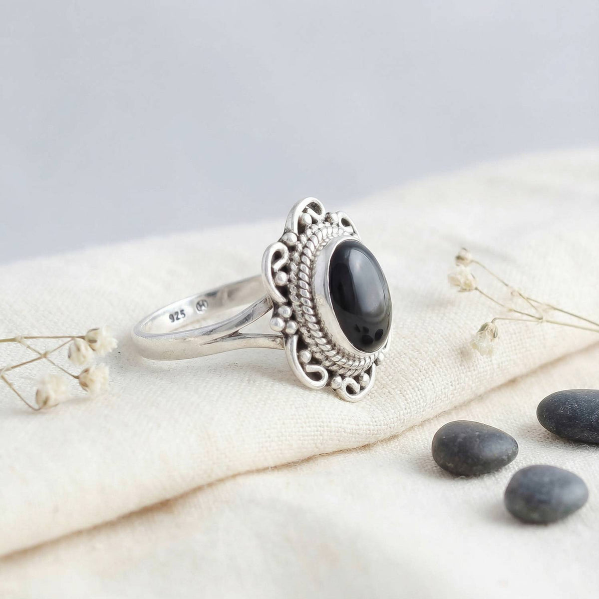 Silberring mit Onyx auf hellem Stoff