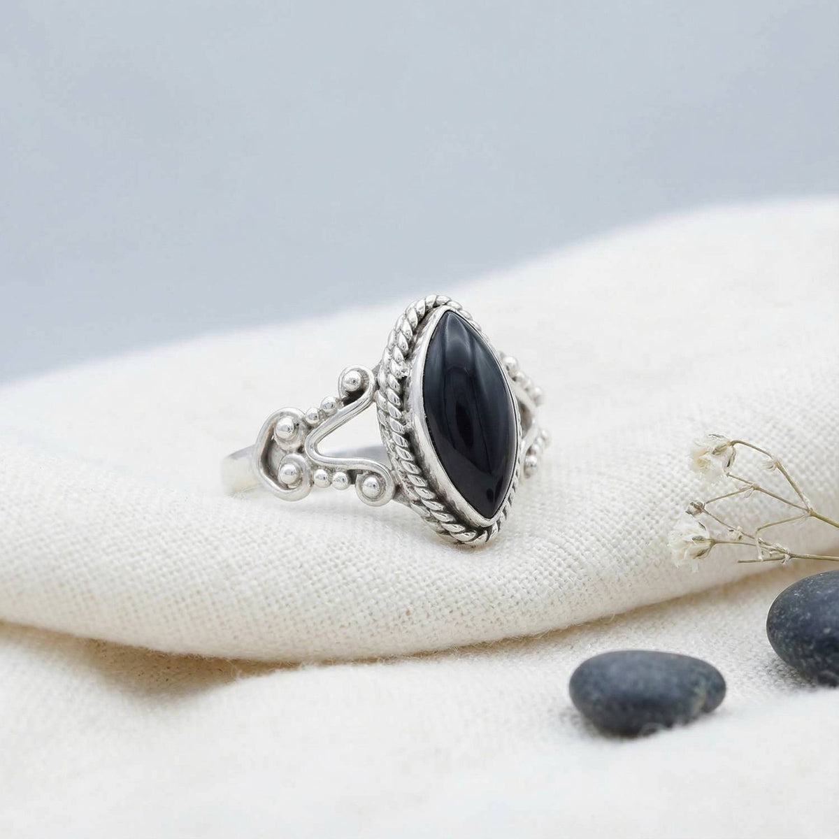 Silberring mit Onyx auf hellem Stoff