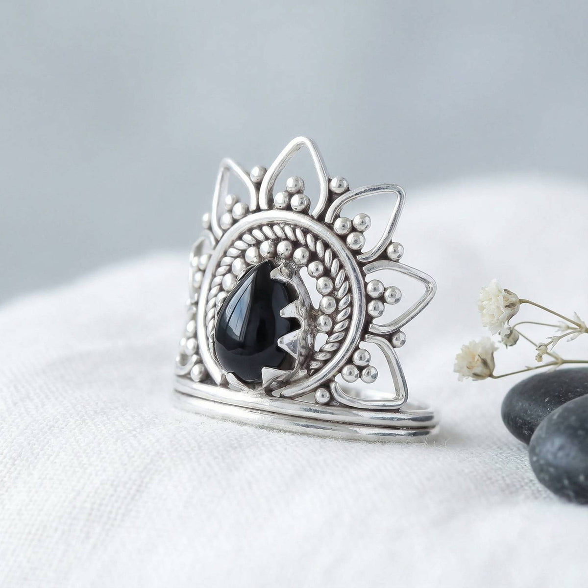 Silberring mit Onyx auf hellem Stoff