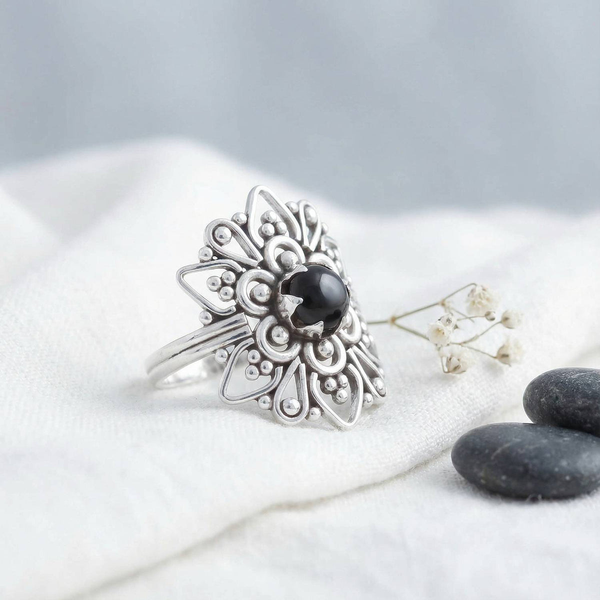 Silberring mit Onyx auf hellem Stoff