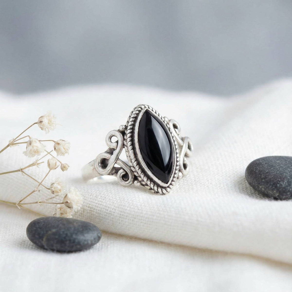 Silberring mit Onyx auf hellem Stoff