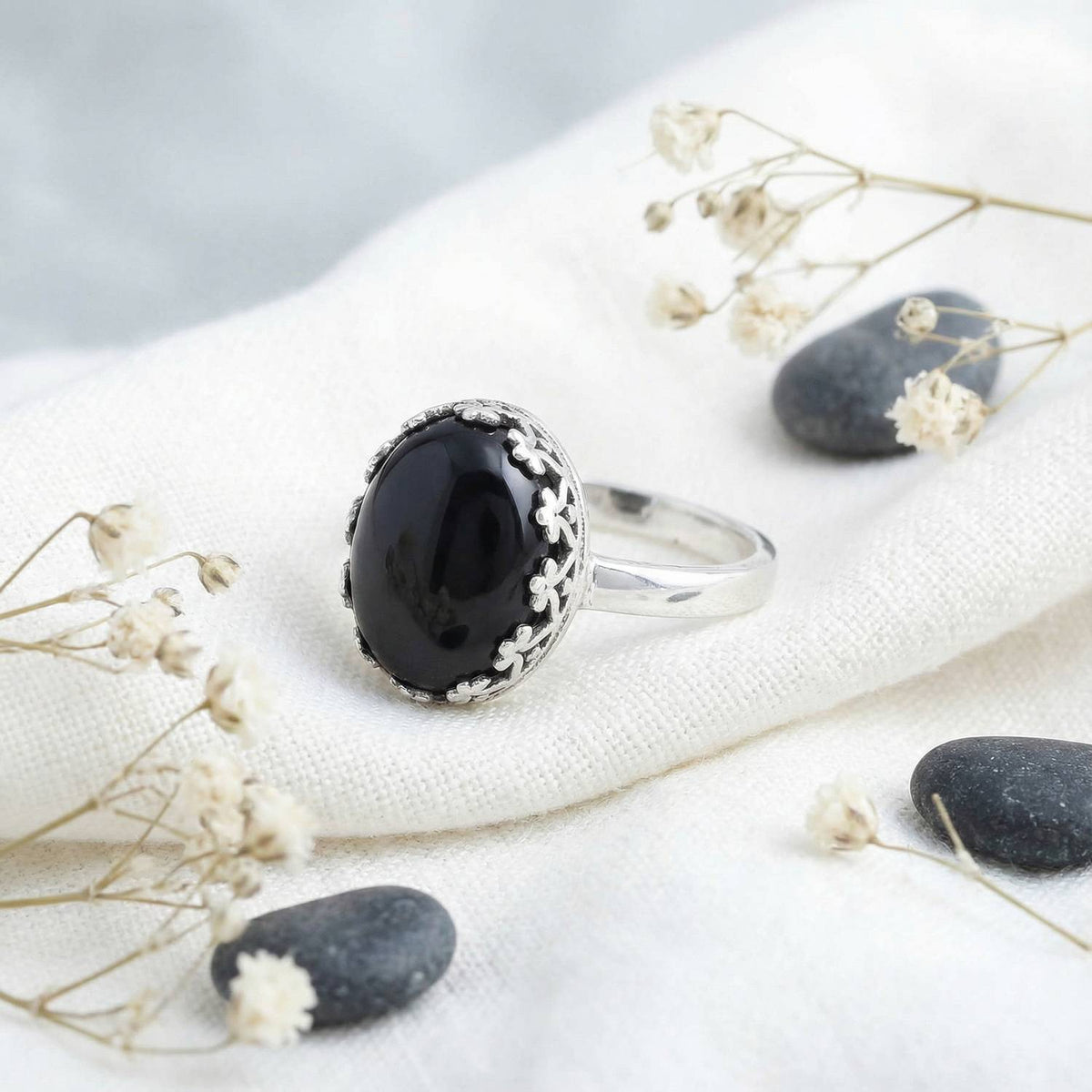 Silberring mit Onyx auf hellem Stoff
