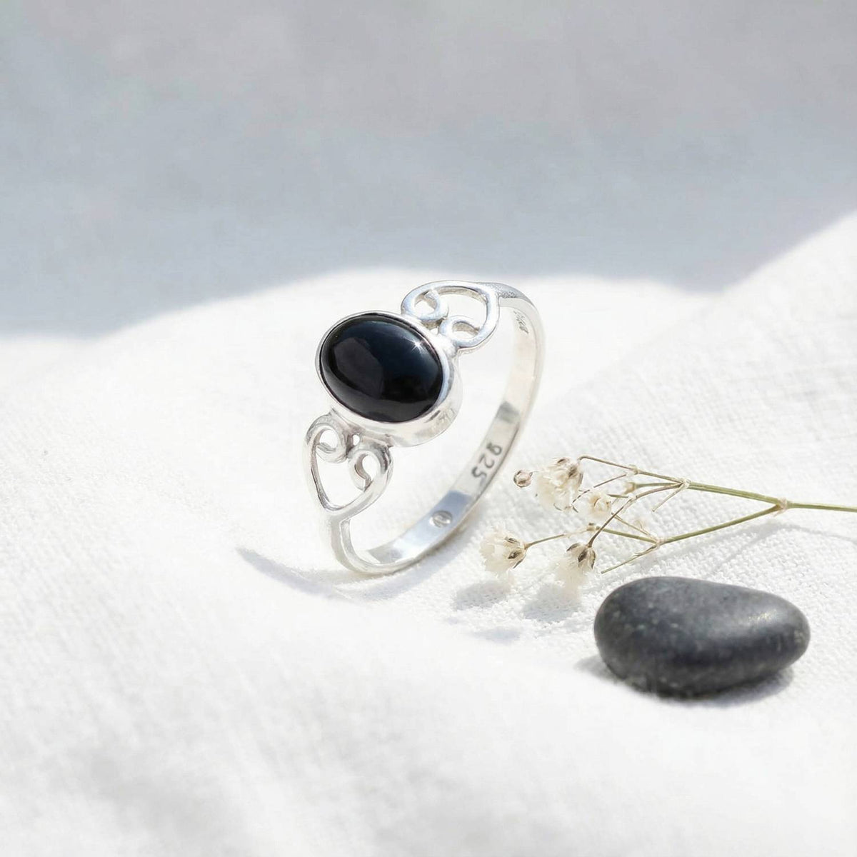 Silberring mit Onyx auf hellem Stoff