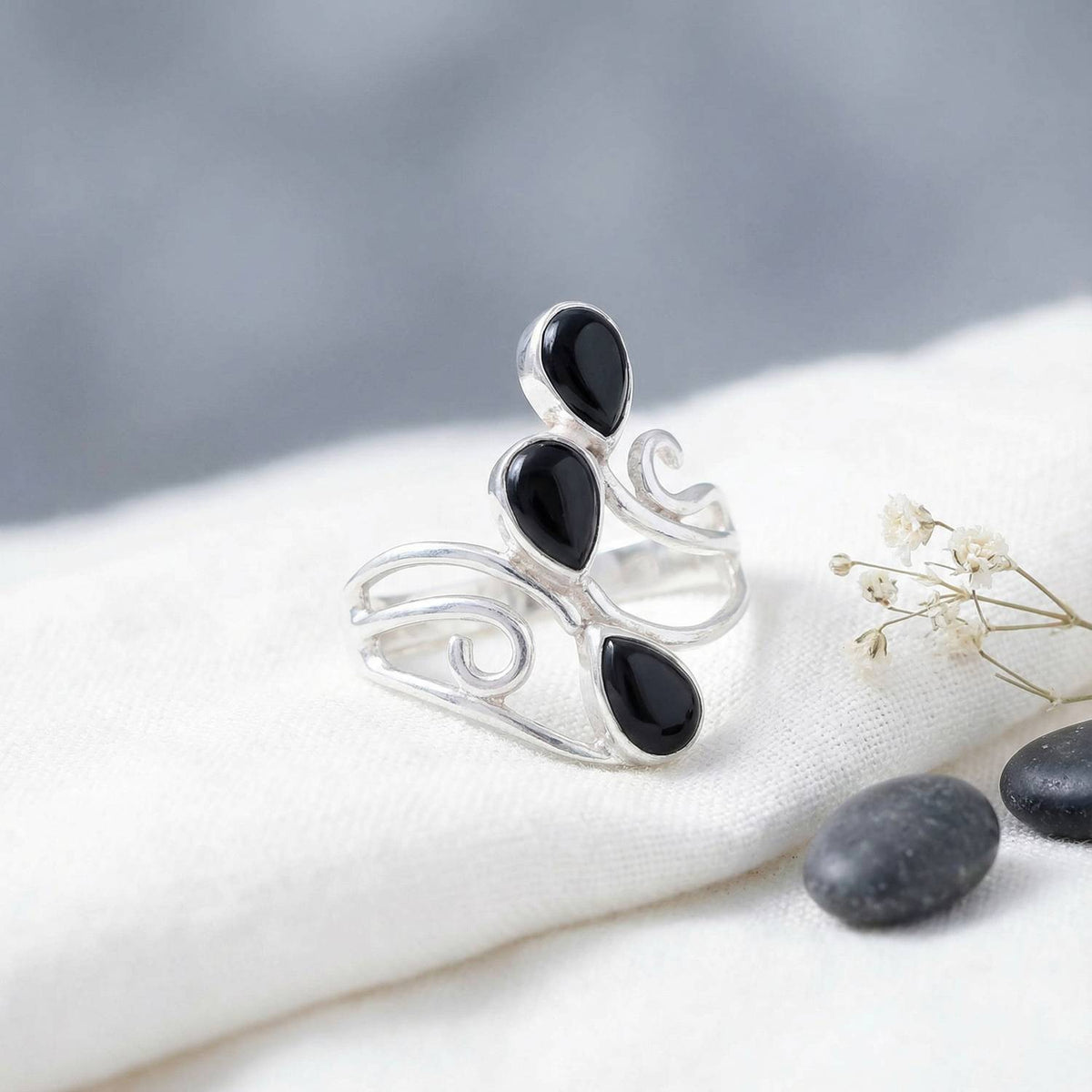 Silberring mit Onyx auf hellem Stoff