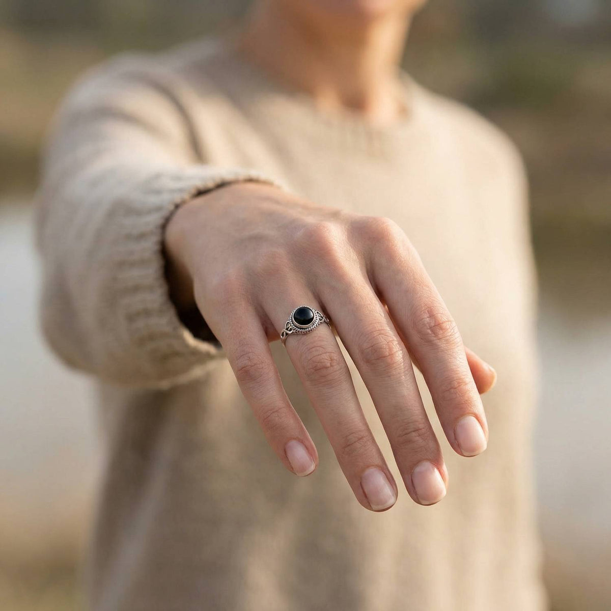 Onyxring aus Silber getragen an der Hand im Freien
