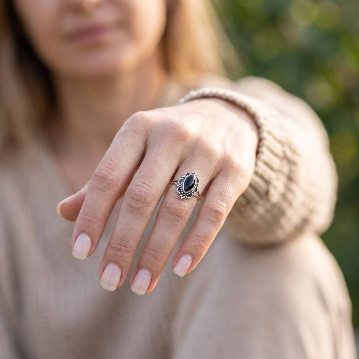 Onyxring aus Silber getragen an der Hand im Freien