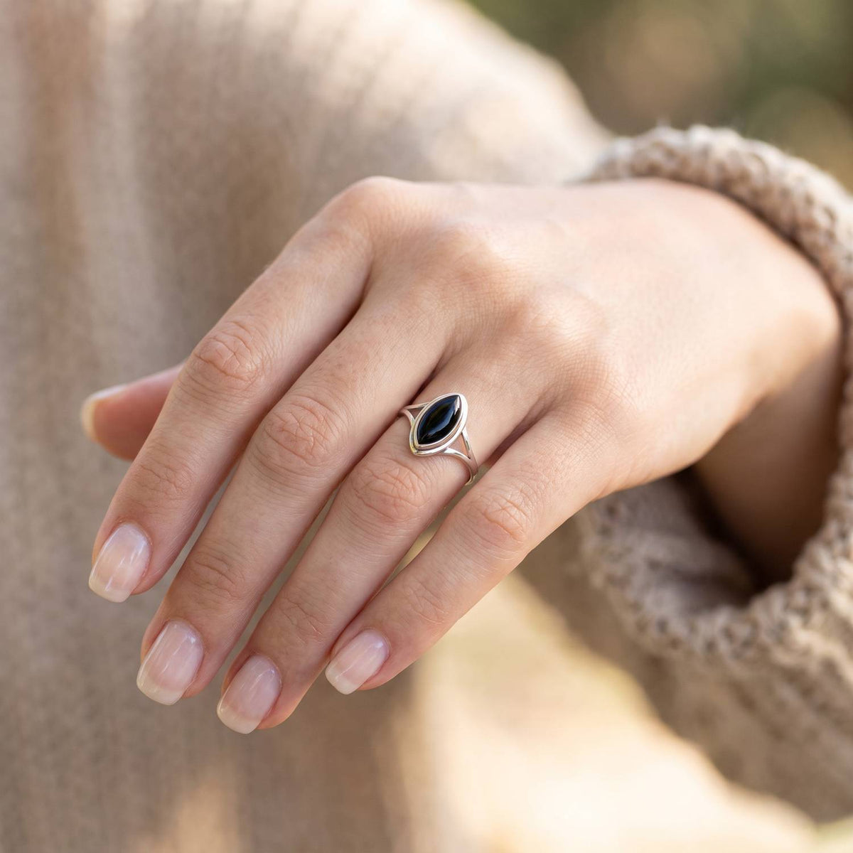 Onyxring aus Silber getragen an der Hand im Freien