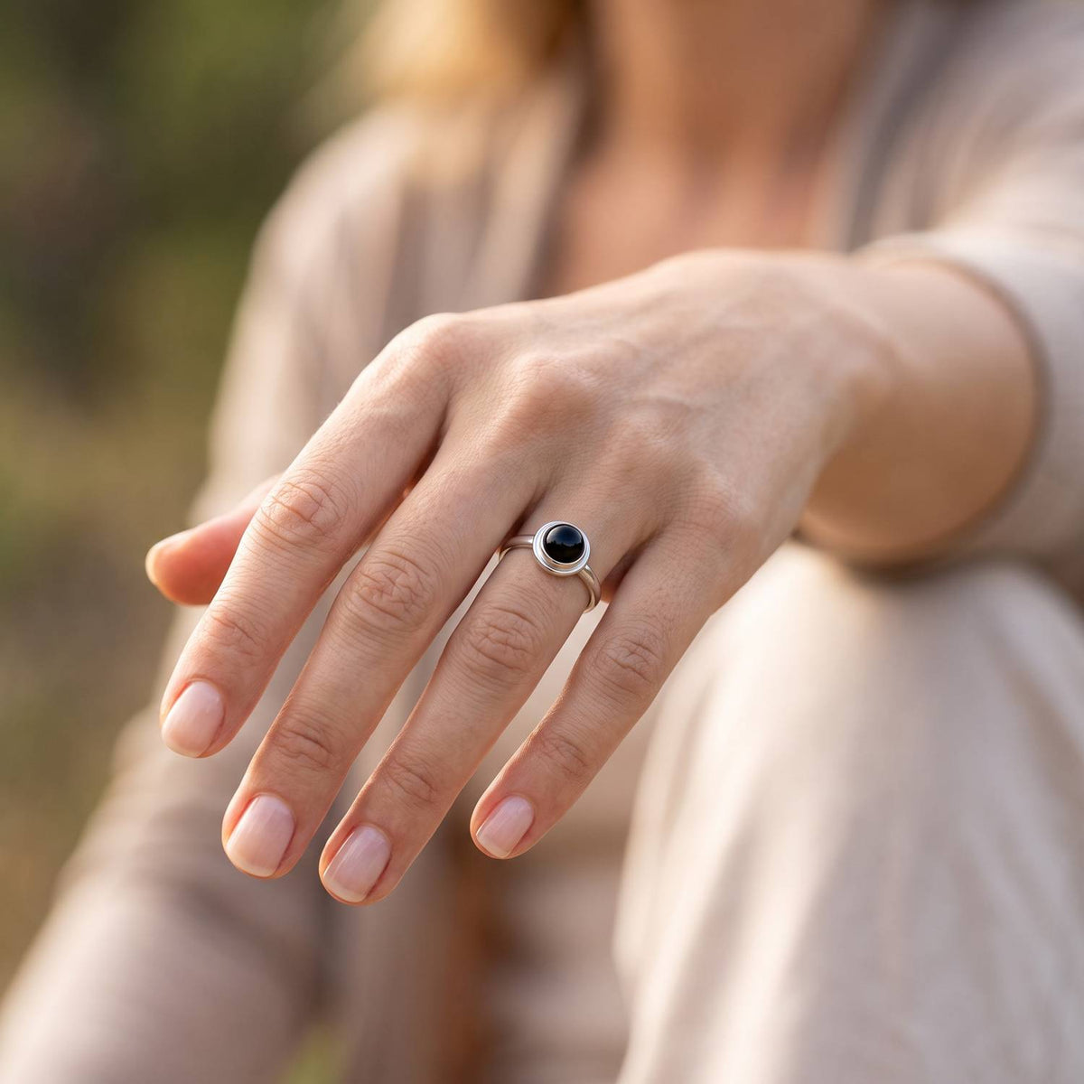 Onyxring aus Silber getragen an der Hand im Freien