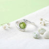 [KI] Silberring mit Peridot auf hellem Stoff