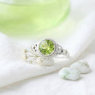 [KI] Silberring mit Peridot auf hellem Stoff