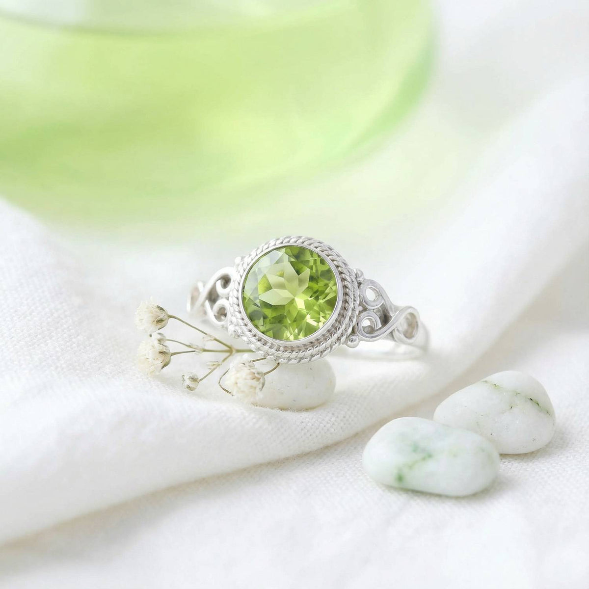 Silberring mit Peridot auf hellem Stoff