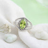 [KI] Silberring mit Peridot auf hellem Stoff
