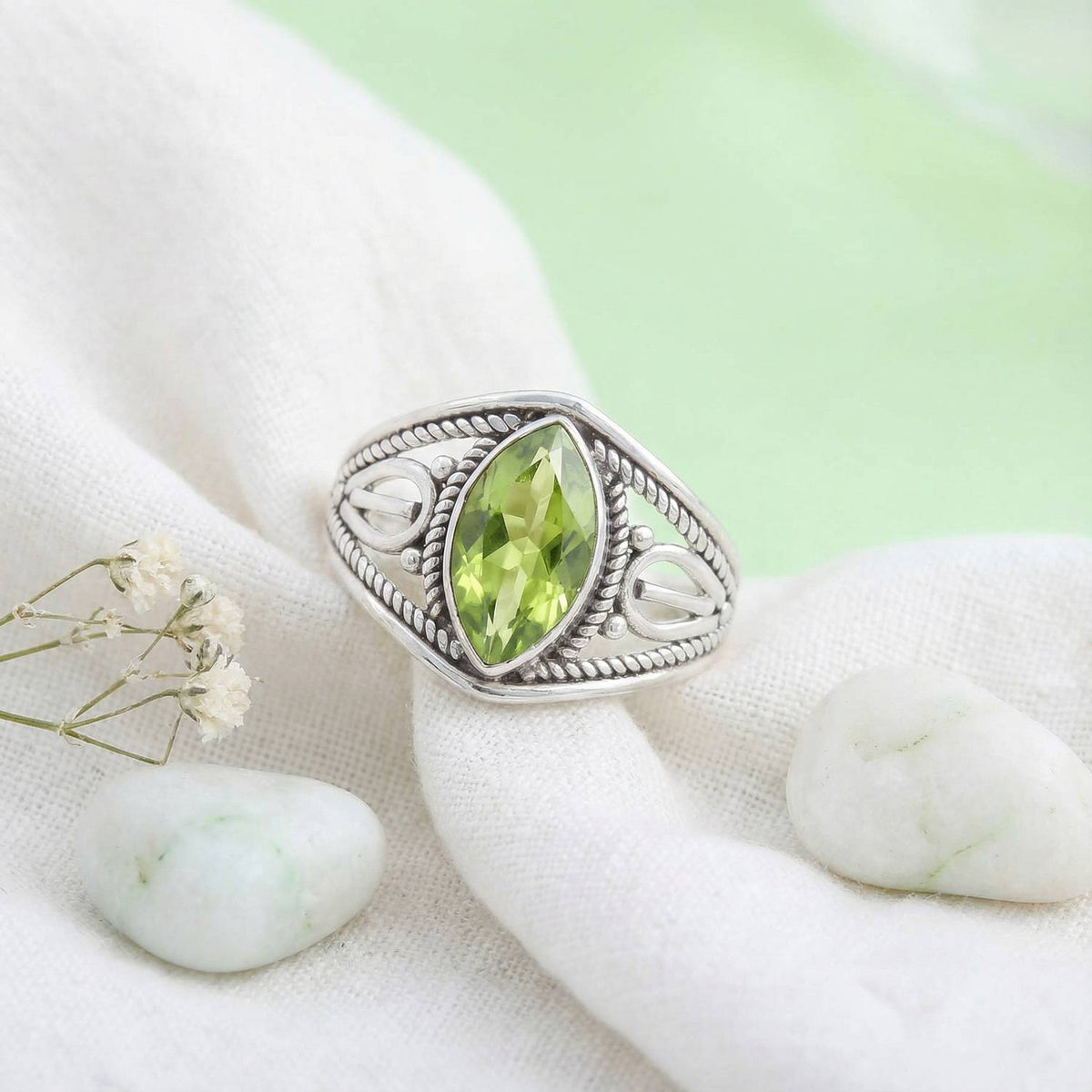 Silberring mit Peridot auf hellem Stoff