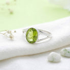 [KI] Silberring mit Peridot auf hellem Stoff