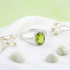 [KI] Silberring mit Peridot auf hellem Stoff
