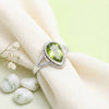 [KI] Silberring mit Peridot auf hellem Stoff
