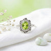[KI] Silberring mit Peridot auf hellem Stoff