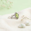 [KI] Silberring mit Peridot auf hellem Stoff