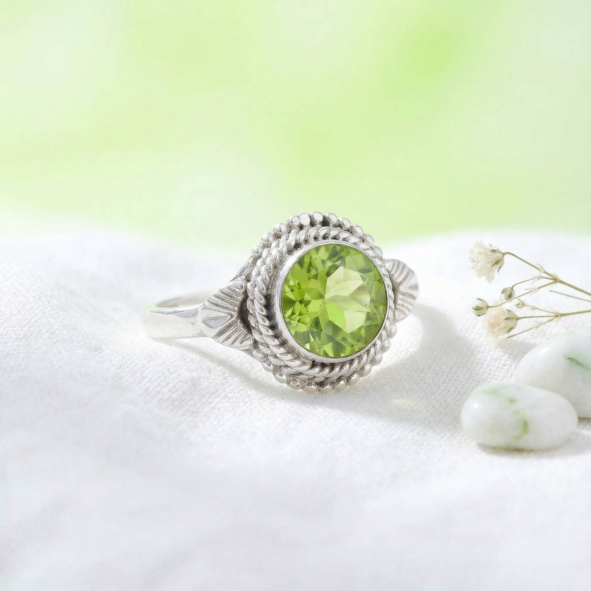 Silberring mit Peridot auf hellem Stoff