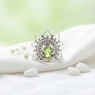 [KI] Silberring mit Peridot auf hellem Stoff