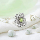[KI] Silberring mit Peridot auf hellem Stoff