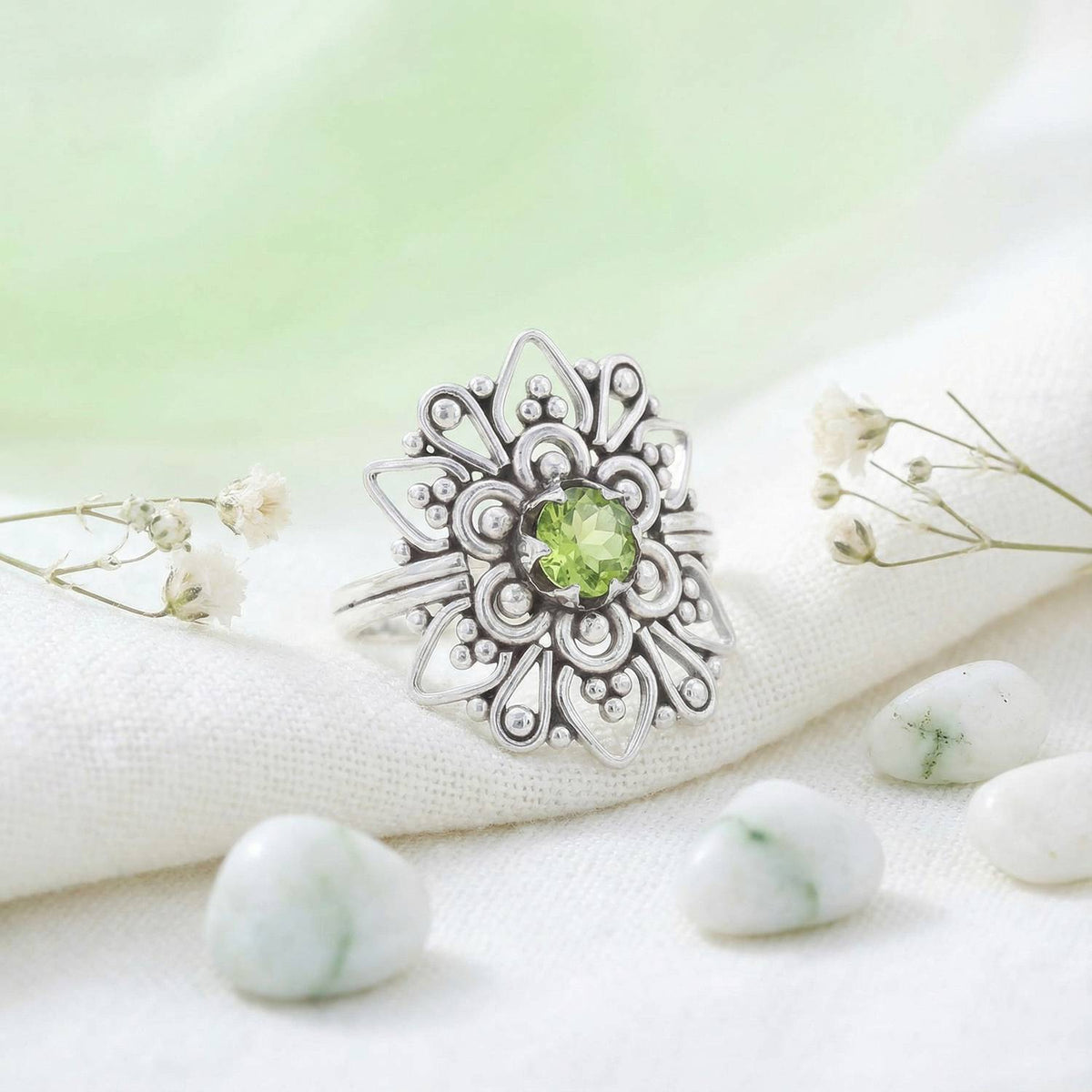 Silberring mit Peridot auf hellem Stoff