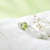 [KI] Silberring mit Peridot auf hellem Stoff
