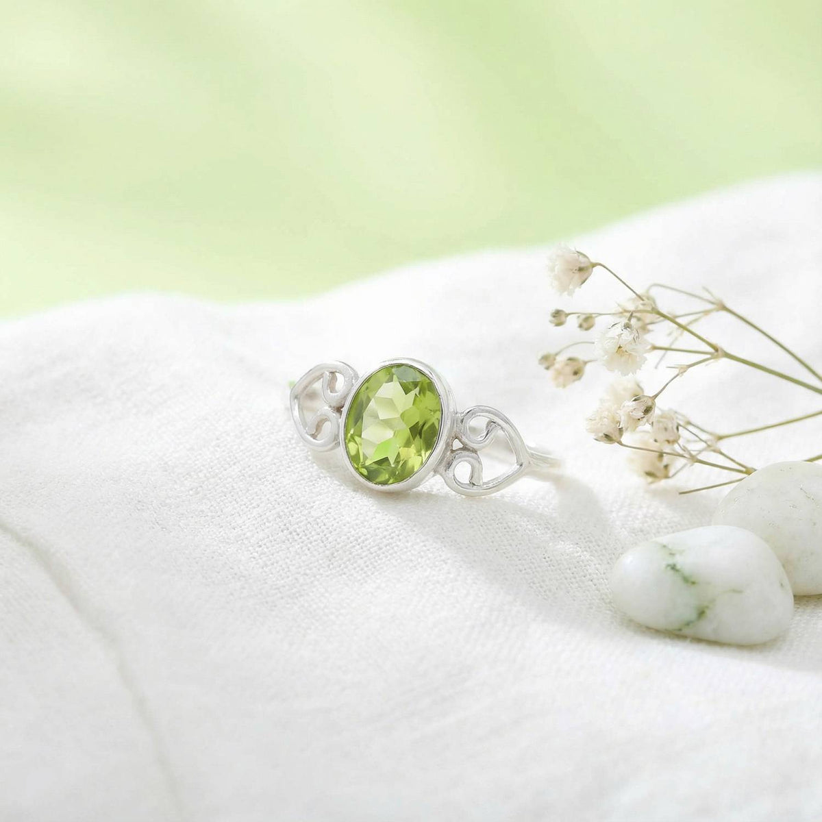 Silberring mit Peridot auf hellem Stoff