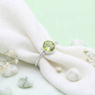 [KI] Silberring mit Peridot auf hellem Stoff