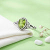[KI] Silberring mit Peridot auf hellem Stoff