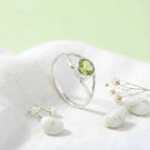 [KI] Silberring mit Peridot auf hellem Stoff