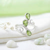 [KI] Silberring mit Peridot auf hellem Stoff