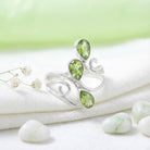[KI] Silberring mit Peridot auf hellem Stoff