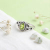 [KI] Silberring mit Peridot auf hellem Stoff