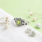 [KI] Silberring mit Peridot auf hellem Stoff