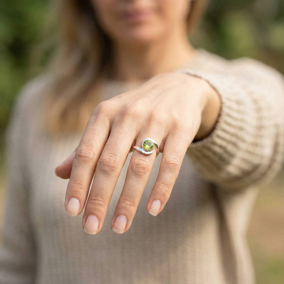 Peridotring aus Silber getragen an der Hand im Freien