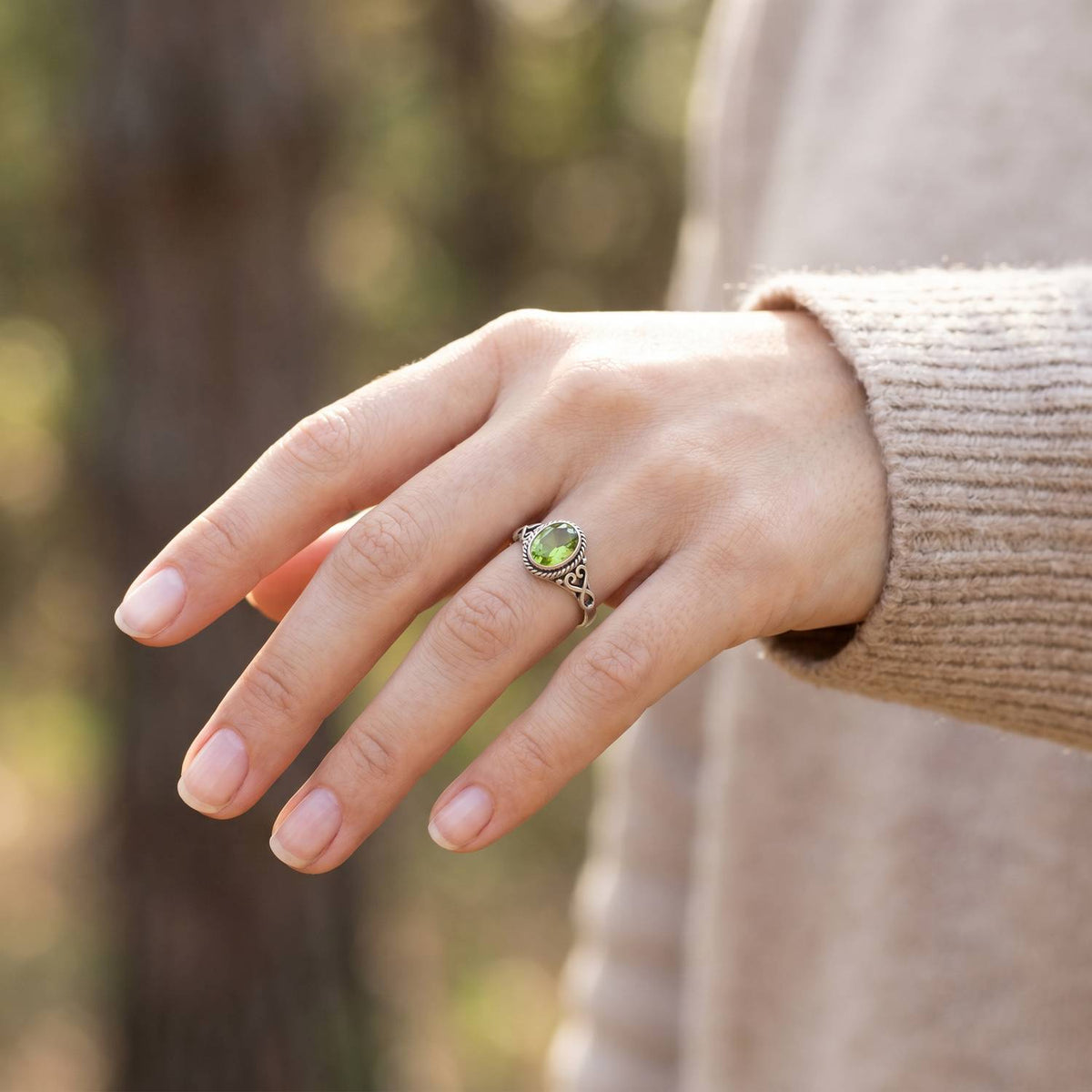 Peridotring aus Silber getragen an der Hand im Freien