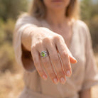 [KI] Peridotring aus Silber getragen an der Hand im Freien