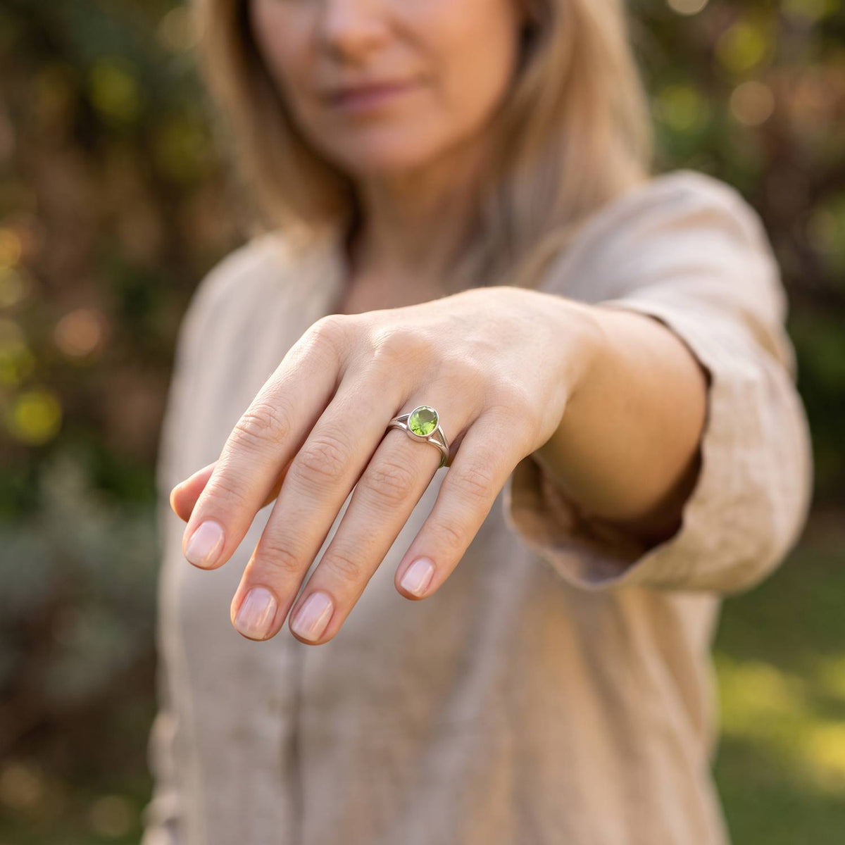 Peridotring aus Silber getragen an der Hand im Freien