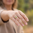 [KI] Peridotring aus Silber getragen an der Hand im Freien