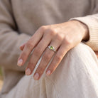 [KI] Peridotring aus Silber getragen an der Hand im Freien
