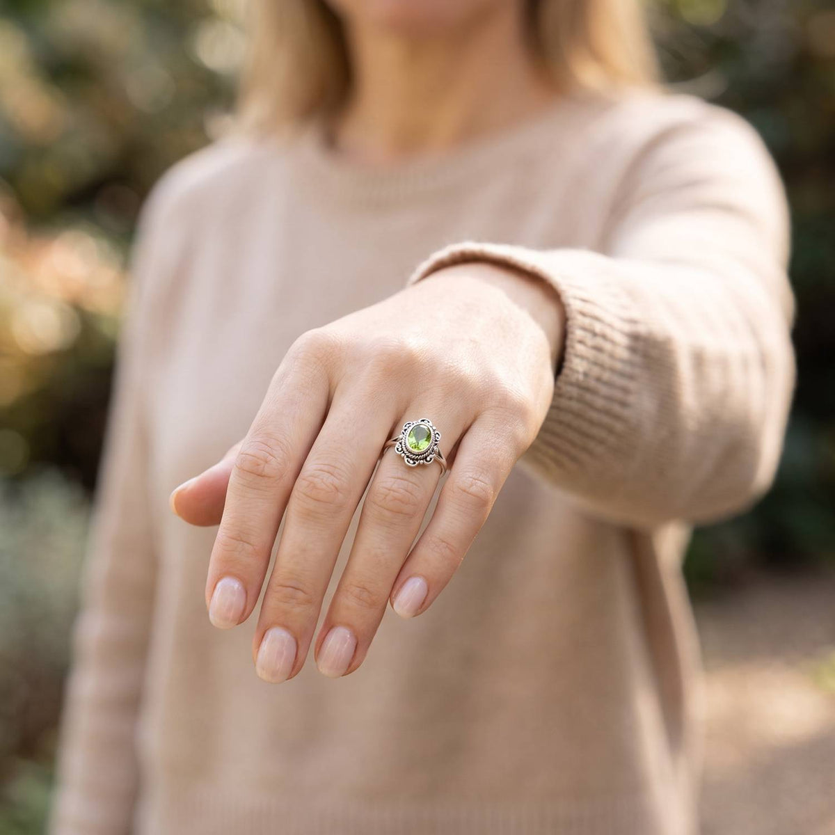 Peridotring aus Silber getragen an der Hand im Freien