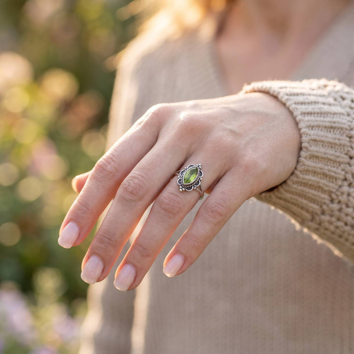 Peridotring aus Silber getragen an der Hand im Freien