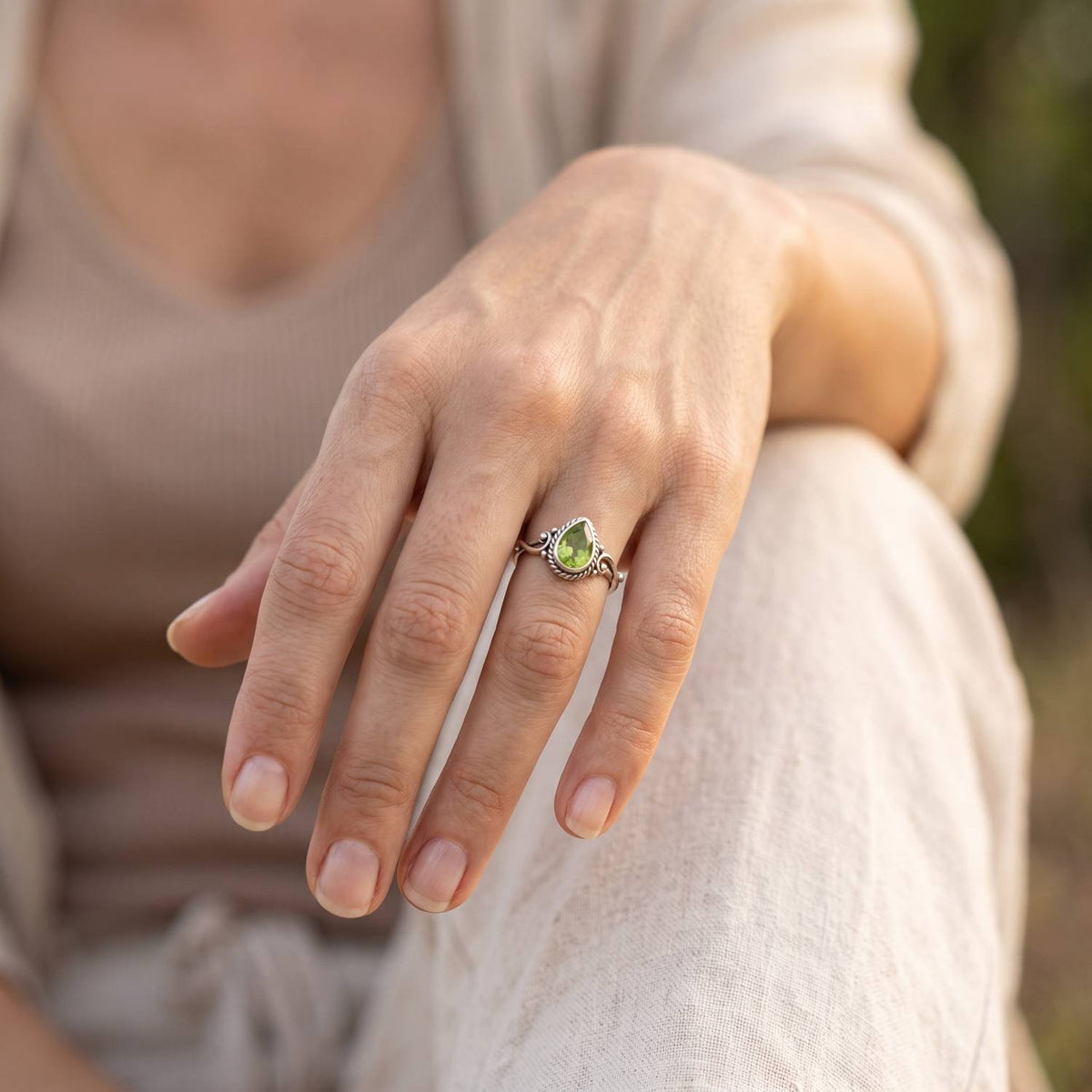 Peridotring aus Silber getragen an der Hand im Freien