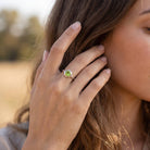 [KI] Frau trägt Silberring mit Peridot an der Hand am Haar