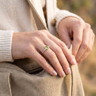 [KI] Frau trägt Silberring mit Peridot beim Griff in eine Tasche