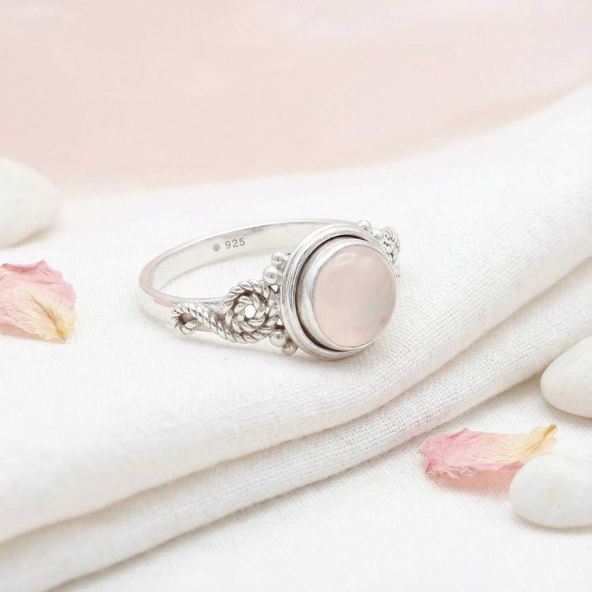 Silberring mit Rosenquarz auf hellem Stoff